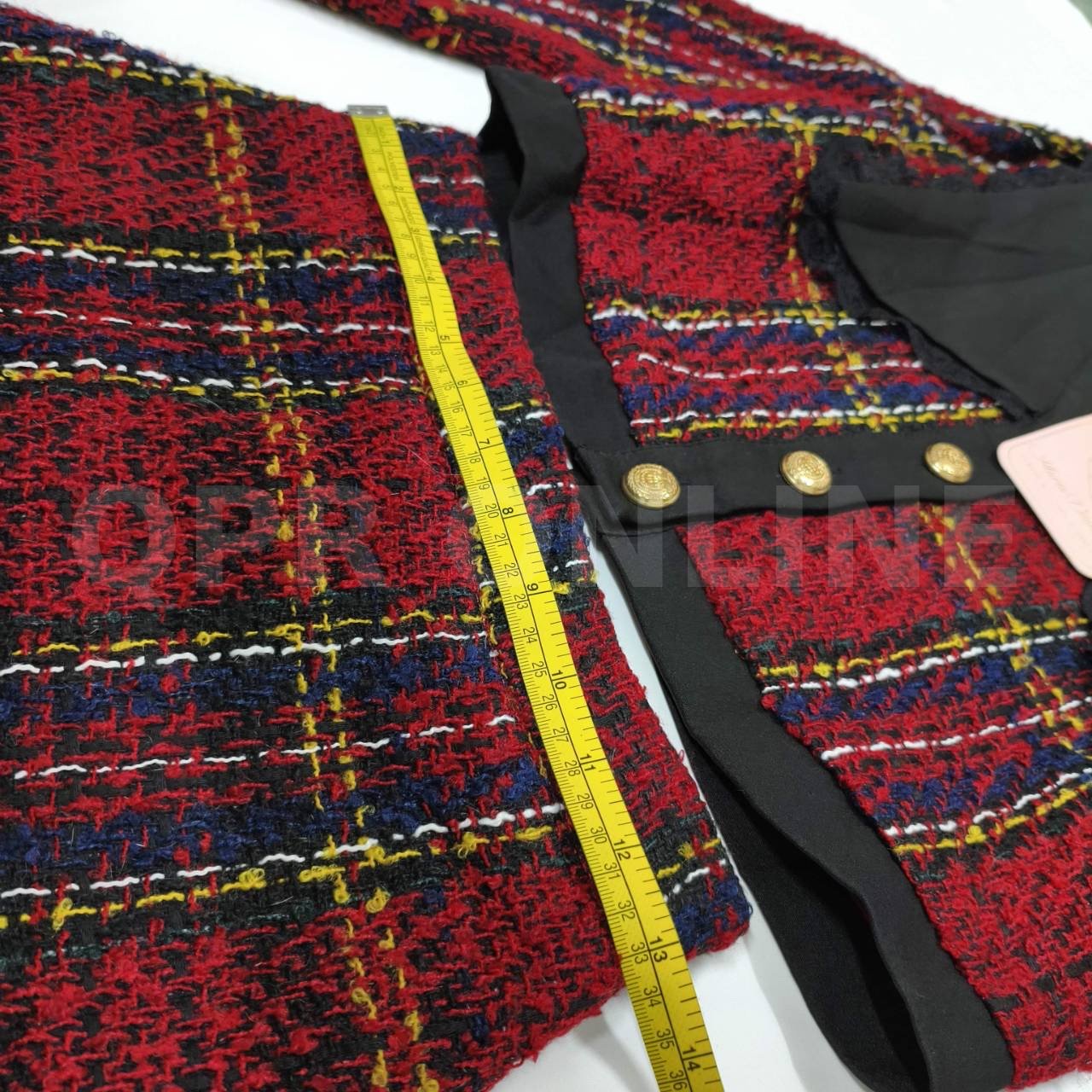 มี (S) Maria Diamond เสื้อครอปแขนยาวผ้าทวีดทอลายตารางสีแดงสลับน้ำเงินและเหลือง โดดเด่นด้วยปกเสื้อสีดำขนาดใหญ่